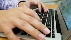 Man is Typing on Laptop Keyboard on Wood Table, Dolly Shot Stock Footage