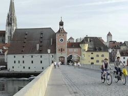 MS People walking over Steinerne Brucke, St. Peter Cathedral on Danube river / Regensburg, Bavaria, Germany Stock Footage