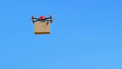SLO MO Drone carrying a package across clear blue sky Stock Footage
