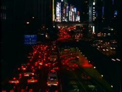 T/L WA High angle view of busy traffic moving through city streets, at night, high-rise buildings on horizon, Chuo Dori, Ginza district, Tokyo, Japan Stock Footage