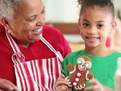 MS Grandmother and Granddaughter Making Gingerbread Men Cookies in Kitchen / Richmond, Virginia, USA Stock Footage