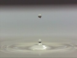 Water droplet falling into water, high speed Stock Footage