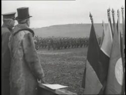 President Woodrow Wilson and General John J. Pershing watch soldiers march in formation across a field. News Clip
