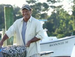 MS Portrait of Smiling Waterman Holding Basket of Fresh Clams / Oyster, Virginia, USA Stock Footage