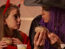 HD DOLLY: Mother And Daughter Eating Halloween Pastries Stock Footage