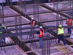Construction workers lower steel beams. Stock Footage