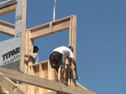 WS ZO Carpenter hammering window frame to rafter while framing an energy efficient post / Grass Lake, Michigan, USA          Stock Footage