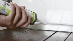 Man Caulks Kitchen Window Stock Footage