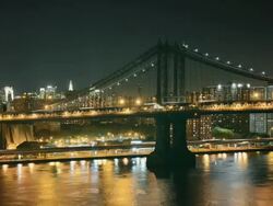 MS TL Night view of Manhattan Bridge with Empire State Building lit in Red, White and Blue / New York, New York, USA Stock Footage