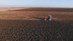 Aerial shot of a tractor plowing a field Stock Footage