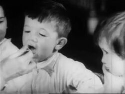 B/W 1934 close up little boy being served spoonful of medicine at nursery school / WPA project / newsreel Stock Footage