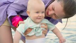 mother with her baby on the beach Stock Footage