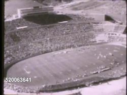 1963: UNITED STATES AIR FORCE ACADEMY: AERIAL: HA WS Flying over Falcon Stadium full of fans, attendees, during game. Sports, recreation, Colorado, CO, Rampart Range Instructional Video