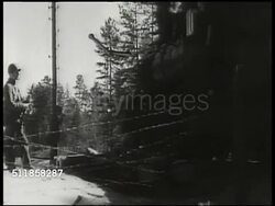 1941: SWEDEN TROOP TRAIN DEAL: Train pulling out of check-point, allowing Nazi German train to pass. Swedish soldier looking over platform edge. Swedish soldiers rolling barbed wire barricade back over track.  WWII, Active neutrality. Instructional Video