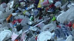 A front loader pushes trash into the back of a dump truck. Stock Footage