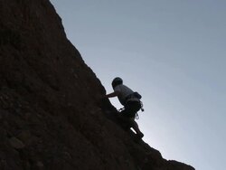 Rock climber scaling cliff Stock Footage
