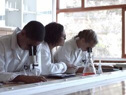 WS Teacher assisting children with microscopes in school lab Stock Footage