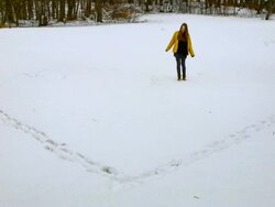 MS T/L Shot of girl walking outline of heart in pristine snow / Ambach, Bavaria, Germany Stock Footage