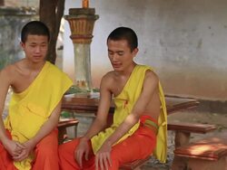 MS SLO Two buddhist monks sitting in yard and chatting / Vientiane, Laos Stock Footage