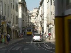 WS View of trams moving at Conceicao street with background people / Lisbon, Portugal Stock Footage