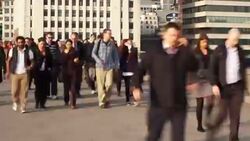 Commuters walk across London Bridge in England. Stock Footage