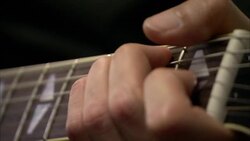 A hand strums an electric guitar. Stock Footage
