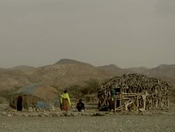 Afar people by their huts Stock Footage