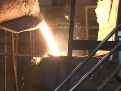 Medium Close Up static - A cast iron bucket pours molten metal into a container /  Ohio, United States Stock Footage
