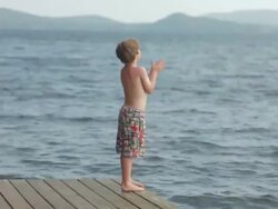WS Boy standing on dock and jump in to lake / WOLFEBRO, NH, USA   Stock Footage