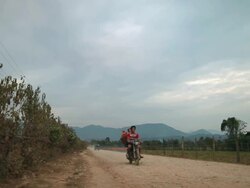 WS PAN People travellin with tractor cart and motorcycles on dirt road /  Vang Vieng, Vientiane, Laos Stock Footage
