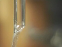 CU, SELECTIVE FOCUS, Water dripping and pouring from glass tube Stock Footage