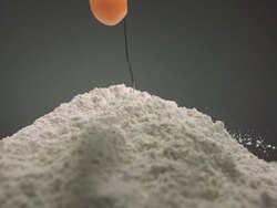 CU SLO MO Egg yoke falling in flour Stock Footage