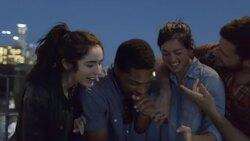 Group of friends look at smartphone and laugh together on Pfluger Bridge with downtown Austin, Texas skyline in background Stock Footage