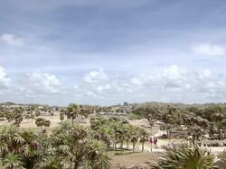WS View over part ofTulum ruins, lots of tourists andworker with wheelbarrow / Tulum, Quintana Roo, Mexico Stock Footage
