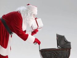 Santa Claus puts a gift in Baby Carriage Stock Footage