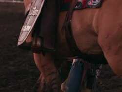 A cowboy with cowboy hat and chaps walks away from camera after a wild ride at a rodeo - shot in slow motion. Stock Footage
