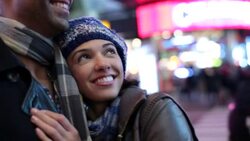 Young couple in love hold each other close while taking in the sights and sounds of Times Square Stock Footage