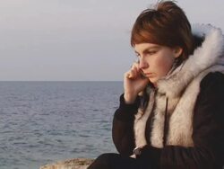 Girl on the coast with phones Stock Footage