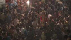 A huge crowd watches as Diwali participants carry a goddess statue along a street in India. Stock Footage