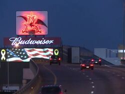 Classic Budweiser billboard lights up highway Stock Footage