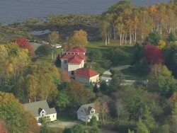MS AERIAL TU View of small house surrounded by trees at bay / Maine, United States Stock Footage