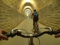 MS POV Shot of two people cyclist cycling with cycle helmet through tunnel area / Echternach, Luxembourg Stock Footage