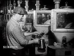 1947: STANDARD OIL (INDIANA): REFINERY: TU UNDER Elevated oil pipeline. Worker taking sample of gas, CU Automotive gasoline flowing behind glass window of containment unit. Instructional Video
