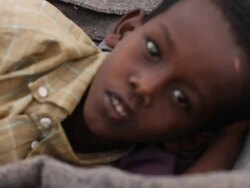 Man carrying sick child inside a wheel barrel Stock Footage