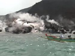 Boat Sails Past Steaming Volcano Lava Flow Stock Footage