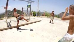 Brazilian street kids juggle soccer ball in slow motion overlooking Rio Stock Footage