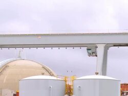 WS ZO from gantry crane to containment structures and cooling towers at nuclear power plant by the sea / Pendleton, California, USA Stock Footage