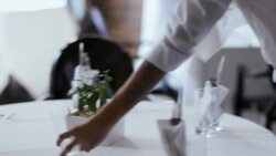 Restaurant staff sets tables and prepares dining room for opening Stock Footage