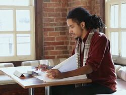 MS Architect using tablet and looking at blueprints in cafe / Santa Fe, New Mexico, United States Stock Footage