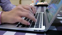 Man is Typing on Laptop Keyboard on Square Pattern Table, Dolly Shot Stock Footage
